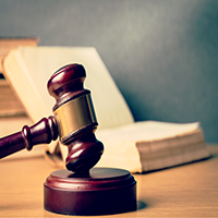 . Image - A gavel in front of an open book. Click tile image to view